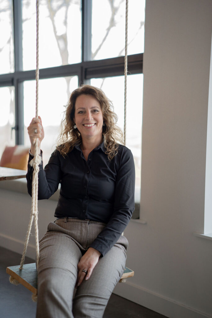 Jannie in zwarte blouse op schommel